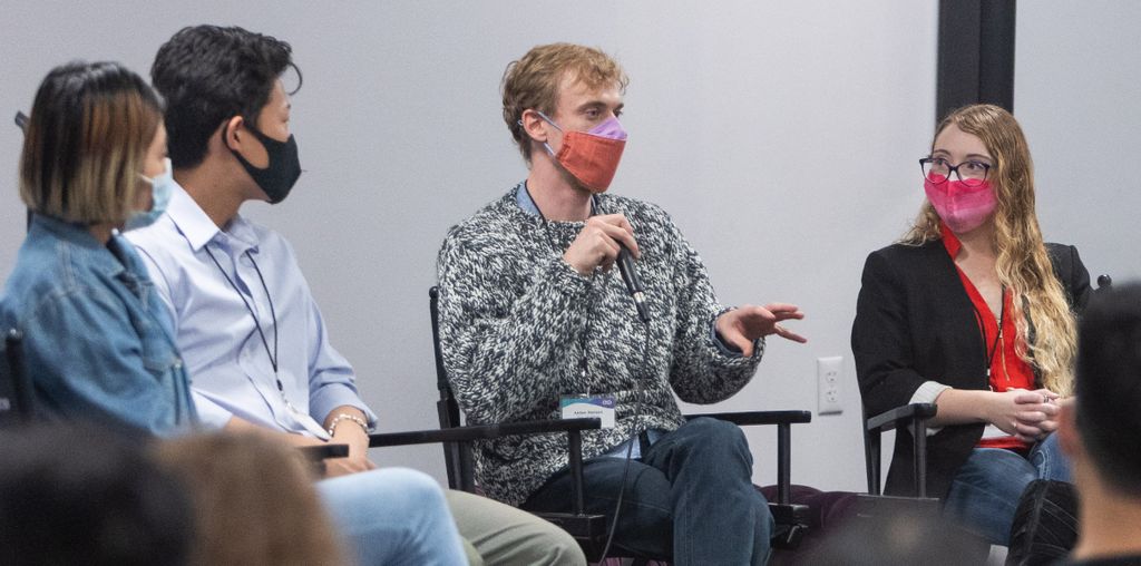 NYU startup community members are shown wearing masks while sitting in a circle discussing COVID-19 related challenges