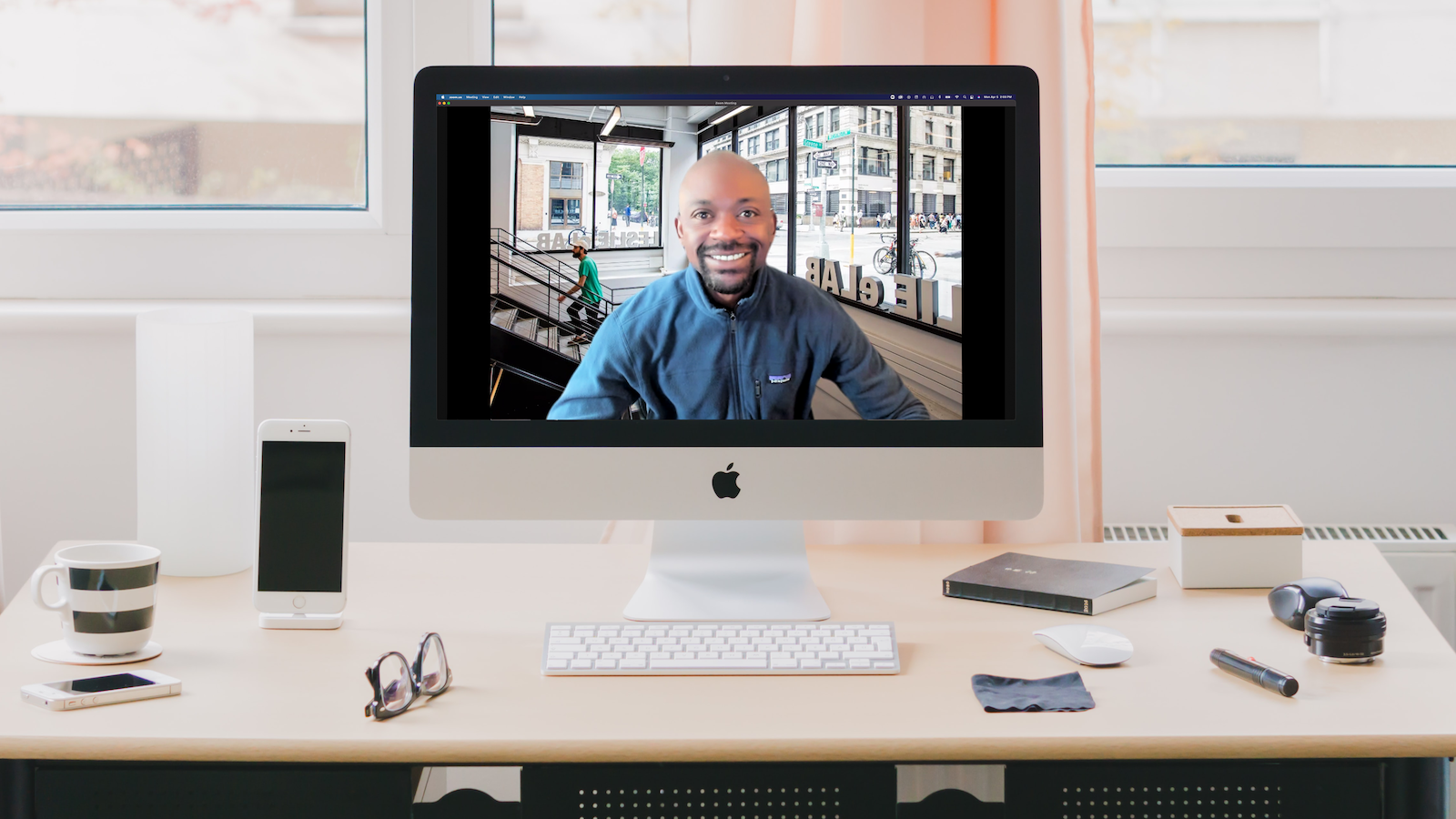 Photo of a desk with a computer showing NYU Entrepreneurial Institute coach Keith Mauppa smiling