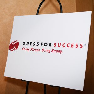 Photo of a poster in a meeting room with the Dress for Success logo.