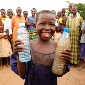 African child holding bottles of water from Charity Water