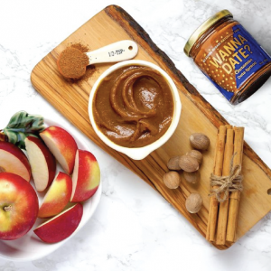 jar of wanna date with some of the spread on a bowl and spoon and some apple slices