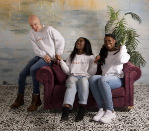 Photo of the Melacast Network founder and participants, laughing and sitting on a sofa